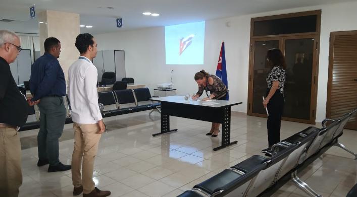 Trabajadores de la OZED Mariel acompañan a tres de los cuadros de reciente aprobación a la firma del Código de Ética. 