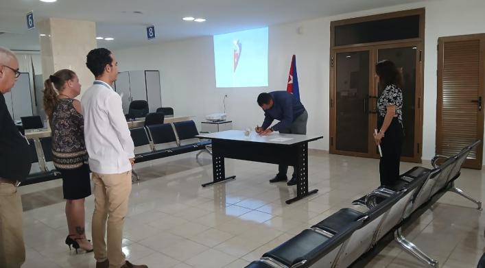 Trabajadores de la OZED Mariel acompañan a tres de los cuadros de reciente aprobación a la firma del Código de Ética. 